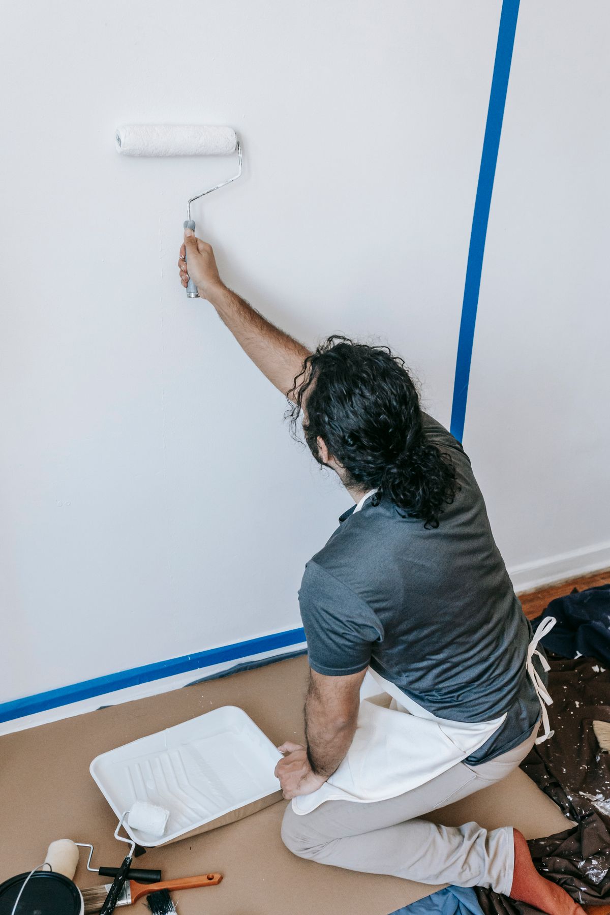 A professional painter rolling fresh paint onto an interior wall